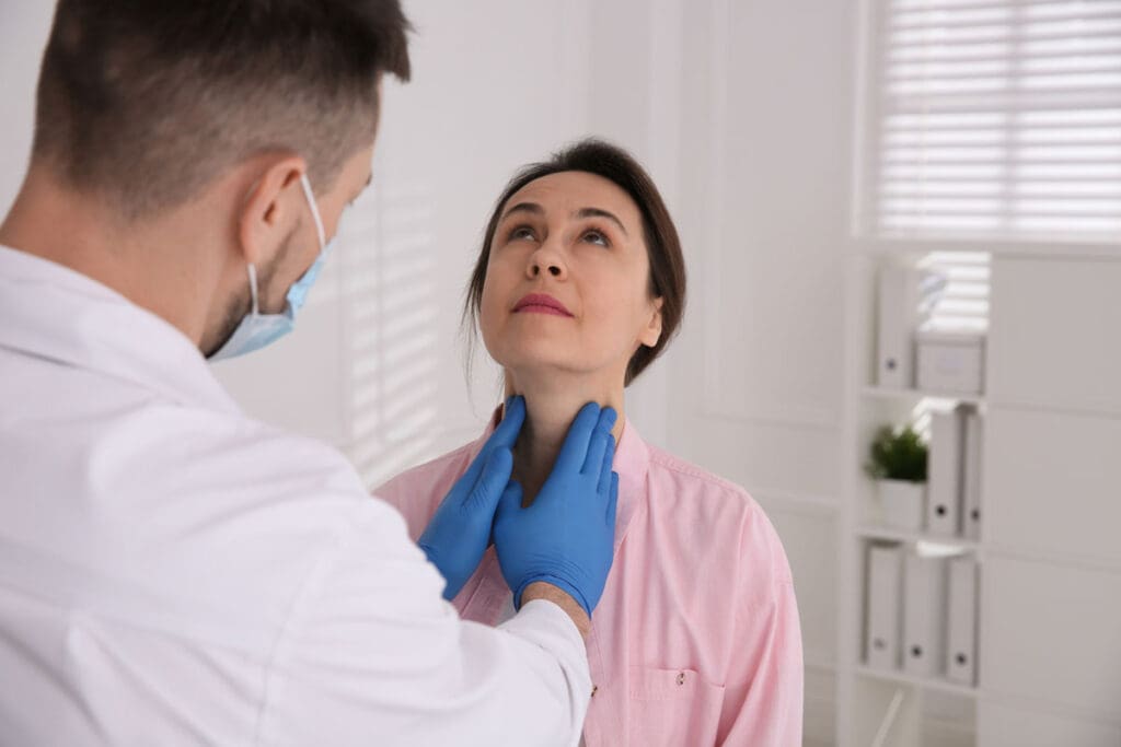 A clinician examines a patient’s thyroid nodule following an RFA procedure