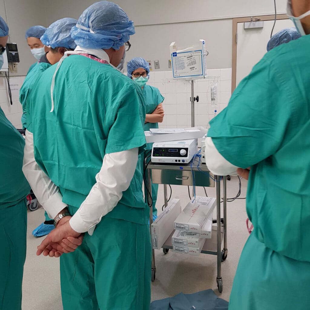 Doctors observe RFA machine in an operating room.