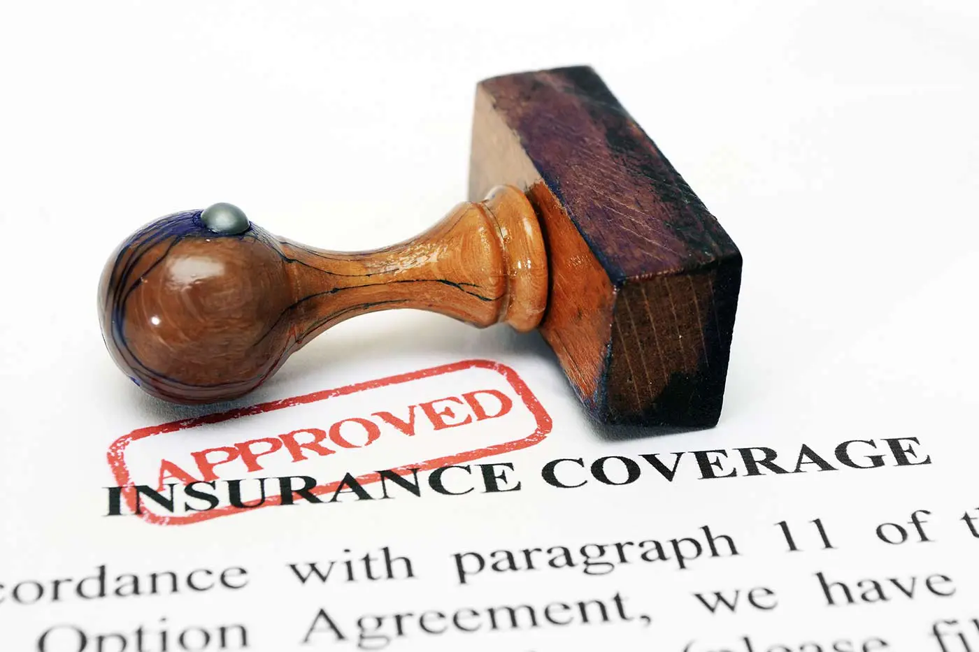 A red approval stamp on top of insurance coverage paperwork.