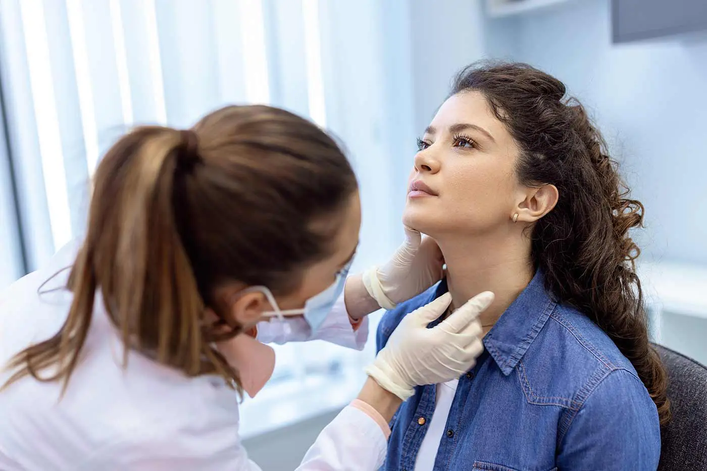 A clinician examines a patient's thyroid before the RFA procedure