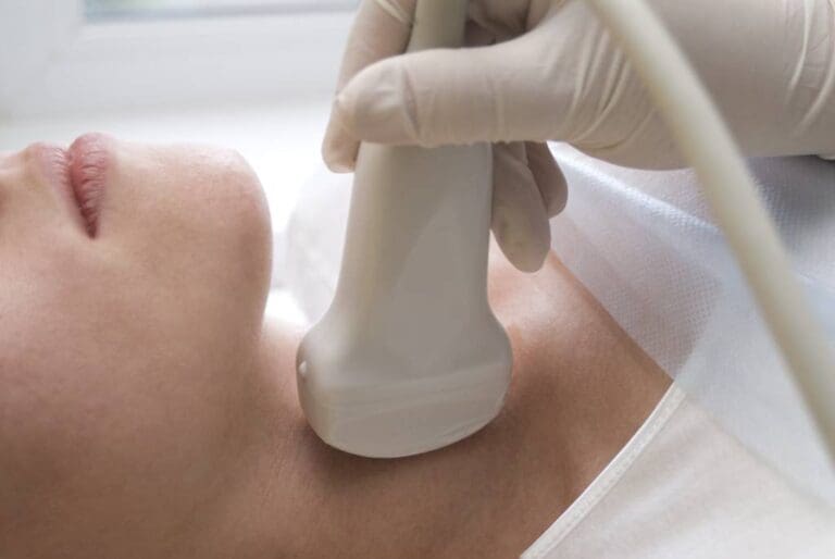 Closeup of a woman receiving an ultrasound of the thyroid.