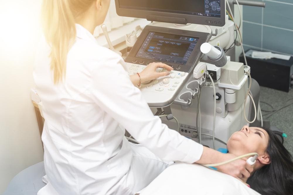A patient receives an ultrasound exam of the neck and thyroid.