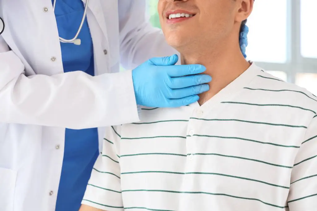 A patient smiles as a clinician examines his healthy thyroid following an RFA procedure.