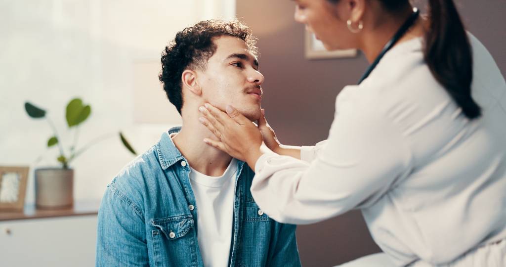 A clinician examines a patient following a radiofrequency ablation treatment of the thyroid.