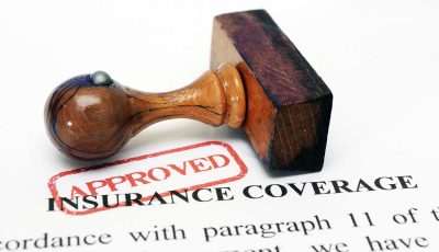 A red approval stamp on top of insurance coverage paperwork.