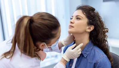 A clinician examines a patient's thyroid before the RFA procedure