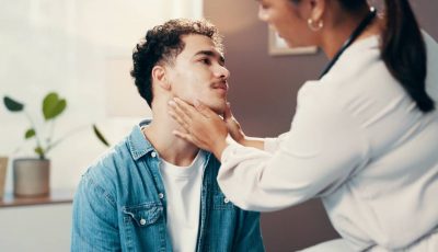 A clinician examines a patient following a radiofrequency ablation treatment of the thyroid.