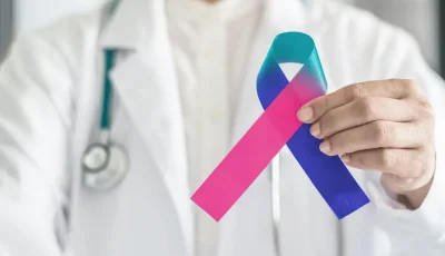 A clinician holds up a thyroid cancer awareness ribbon.